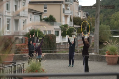 Patienten führen eine Sportübungen mit einem Hula Hoop Reifen durch