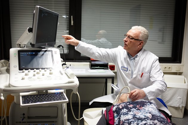 Dr. Enver Shala fürht Ultraschalluntersuchung der Schilddrüse einer Patientin durch - Rheumazentrum Rheinland-Pfalz