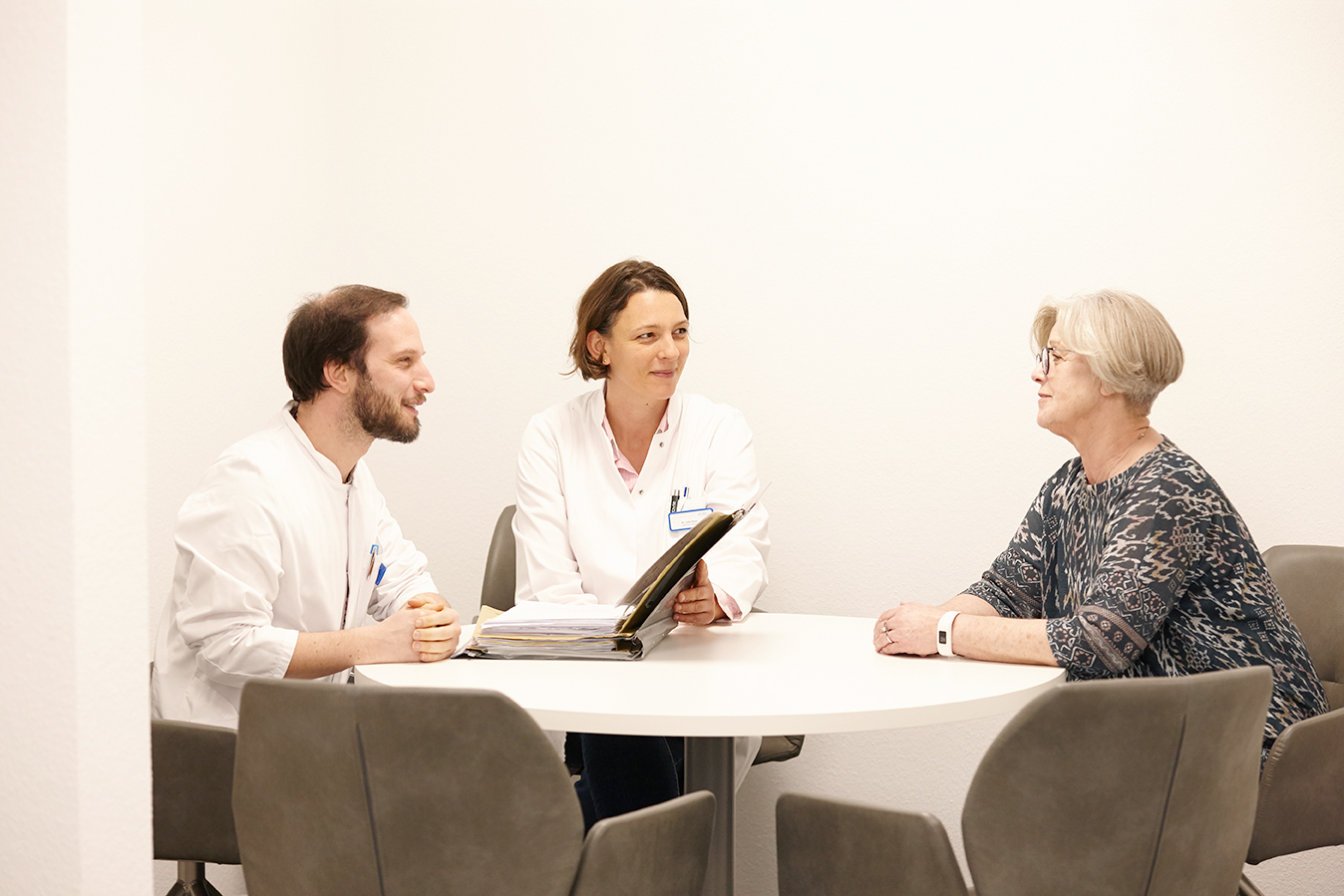 Ärzte am Tisch im Gespräch mit Personal aus Verwaltung - Rheumazentrum Rheinland-Pfalz